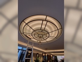 Chandelier on a glass suspended ceiling made of flat glass.