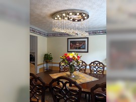 A silver chandelier in the shape of a painter's palette illuminates the dining room table