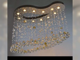 A view of a lit silver chandelier with a pallet mirror