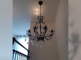 A dark brown chandelier made according to color of a wooden railing