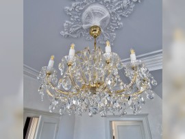 A smaller chandelier on the ceiling of the kitchen