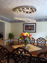 A silver chandelier in the shape of a painter's palette illuminates the dining room table