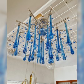 Design variations of modern chandeliers from clear and blue crystal drops reflecting light from ceiling soffits