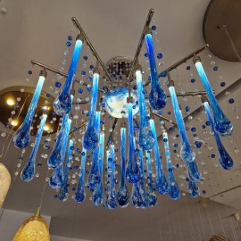 Design variations of modern chandeliers from clear and blue crystal drops reflecting light from ceiling soffits